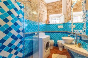 a blue tiled bathroom with a washing machine in it at Casa Bellavista in Baunei