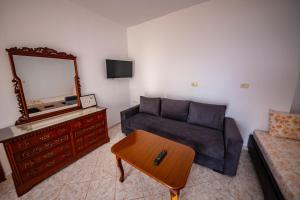 uma sala de estar com um sofá e um espelho em Apartments Cikuli em Sarandë