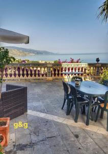 een patio met een tafel en stoelen en een hek bij Casa Dolce Casa - Guest House in Santo Stefano di Camastra