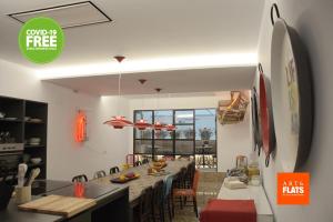 Art&Flats Hostel في فالنسيا: مطبخ مع غرفة طعام مع طاولة طويلة