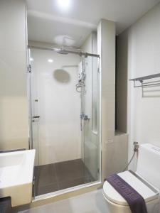 a bathroom with a shower and a toilet at Clover Hotel Hatyai in Hat Yai