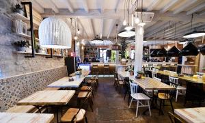 un restaurante con mesas y sillas de madera y un bar en Posada Término, en Hoznayo