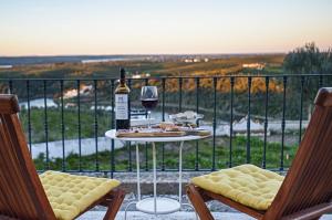 una mesa con una botella de vino y una copa en Casa da Moira, en Avis