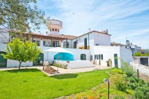 una casa con un césped verde delante de ella en Casa da Moira, en Avis