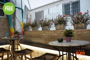 two tables and chairs on a patio with plants at Art&Flats Hostel in Valencia