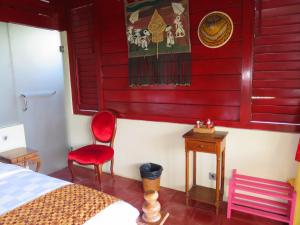 Manggis Garden Dive Resort في كانديداسا: غرفة نوم بسرير وجدار احمر