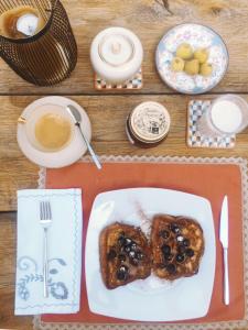 a table with a plate of food and a cup of coffee at La Grechea Boutique B&B in Casa Alzi +10 photos