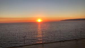 a sunset over the ocean with a fence at Charmant 3 pièces climatisé proche Garibaldi in Nice