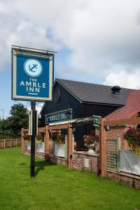 una señal para la posada de ámbar frente a un edificio en The Amble Inn - The Inn Collection Group en Amble