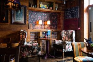 een bar met 2 stoelen en een tafel in een kamer bij The Amble Inn - The Inn Collection Group in Amble