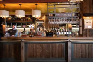 un hombre sentado en un bar en un pub en The Amble Inn - The Inn Collection Group, en Amble