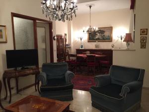 salon z krzesłami, telewizorem i stołem w obiekcie Casa Cristina w Rapallo