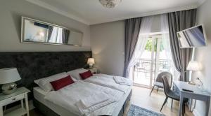 ein Schlafzimmer mit Bett, Schreibtisch und Fenster in der Unterkunft AM Hotel Kaštieľ & Restaurant in Rimavská Sobota