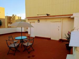 a patio with a table and chairs and an umbrella at El Verd in L'Ametlla de Mar