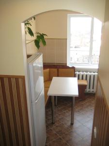 a kitchen with a table and a refrigerator at Комфортная 1-комнатная Новопречистенская 1 in Cherkasy