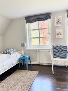 a bedroom with a bed and a blue table and a window at Ferienwohnung Hochdorfer Garten in Tating