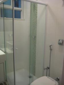y baño con ducha de cristal y aseo. en Apartamento Ed Cadima, en Río de Janeiro