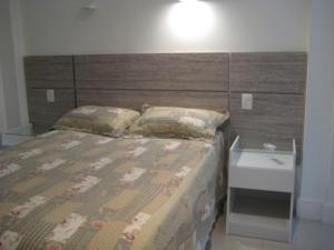 um quarto com uma cama grande e uma cabeceira em madeira em Apartamento Ed Cadima no Rio de Janeiro