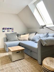 ein Wohnzimmer mit einem Sofa und einem Fenster in der Unterkunft Ferienwohnung Hochdorfer Garten in Tating