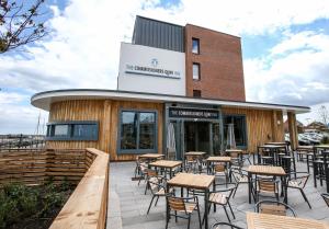 a restaurant with tables and chairs in front of a building at The Commissioners Quay Inn - The Inn Collection Group in Blythe