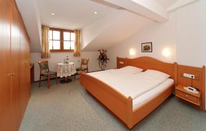 Schlafzimmer mit einem Bett, einem Tisch und Stühlen in der Unterkunft Gasthof-Pension-Kraus in Achslach