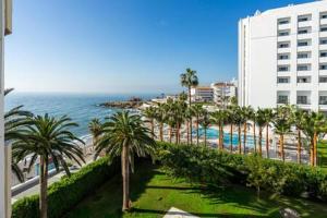 a view of a resort with palm trees and the ocean at Torresol in Nerja