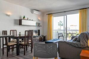 a living room and dining room with a table and chairs at Torresol in Nerja