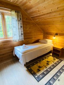 1 dormitorio con 1 cama en una habitación de madera en Mo Laksegard en Sand