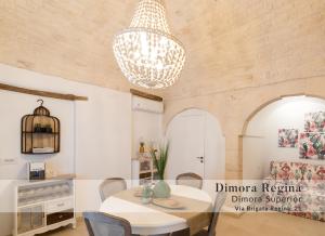 una sala da pranzo con tavolo e lampadario pendente di Dimore nel Tempo - Widespread Homes & Trulli ad Alberobello
