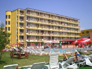 a hotel with chairs and a pool with people sitting at Hotel Trakia Garden in Sunny Beach