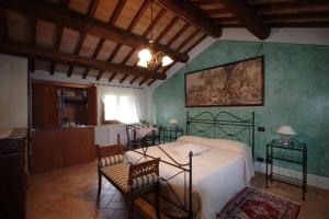 1 dormitorio con 1 cama y sillas en una habitación en Agriturismo L'Ulivo in Fiore, en Spoleto
