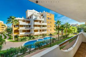 apartamentowiec z basenem i palmami w obiekcie Apartament Delux-La Entrada Punta Prima w mieście Torrevieja