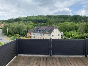 a black gate on a deck with a house at Ferienwohnungen Schewe I in Bad Eilsen