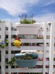 a white fence with a pot of plants on it at MandorleOlio in Polignano a Mare