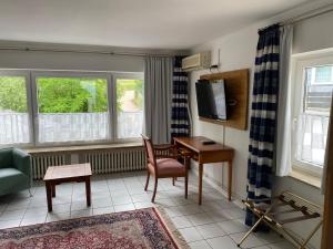 a living room with a desk and a tv at Ferienwohnungen Schewe I in Bad Eilsen