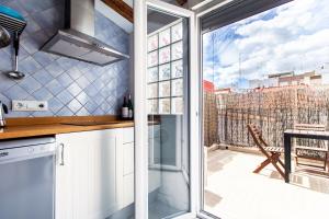 a kitchen with a sliding glass door and a balcony at Precioso estudio con terraza privada en la playa in Valencia