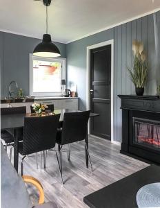 a living room with a table and a fireplace at Solhaug Fjordcamping in Geiranger