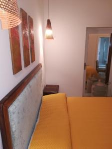 a living room with a yellow couch and a mirror at MandorleOlio in Polignano a Mare