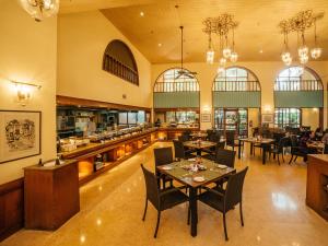 a restaurant with tables and chairs and a kitchen at Acron Candolim Regina in Candolim