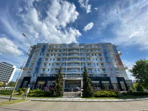a large building with a car parked in front of it at Apartament prywatny salon z aneksem kuchennym i sypialnią w hotelu Diva in Kołobrzeg