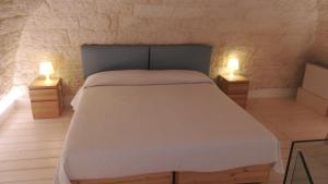 a bedroom with a bed and two lights on tables at MandorleOlio in Polignano a Mare