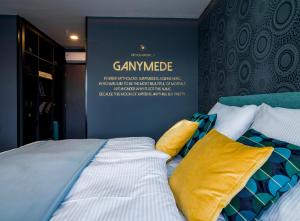 sypialnia z łóżkiem z żółtymi poduszkami w obiekcie Rooftop Planet Prague Hotel w Pradze
