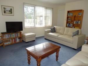 un soggiorno con divano e tavolino da caffè di Bambra Reef Lodge a Sandford