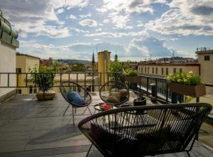 a balcony with chairs and a view of a city at Rooftop Planet Prague Hotel in Prague