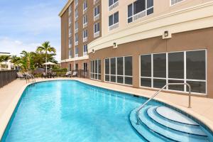 uma piscina em frente a um edifício em Holiday Inn Express Hotel & Suites Fort Myers East - The Forum, an IHG Hotel em Fort Myers