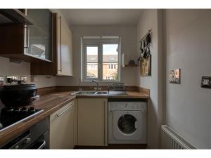 a kitchen with a washing machine and a sink at Peaceful terrace house with allocated parking bay in Reading