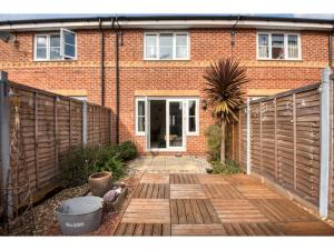 a wooden walkway in front of a brick house at Peaceful terrace house with allocated parking bay in Reading