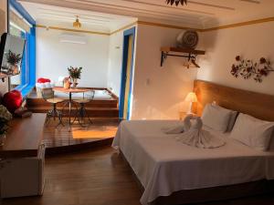 a bedroom with a bed and a table in a room at Hotel Recanto do Ouro in Ouro Preto +132 photos