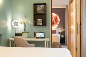 a room with a bed and a desk with a laptop at Cascada Boutique Hotel in Lucerne