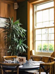 uma sala de jantar com uma mesa e um vaso de plantas em The Grazing Goat em Londres